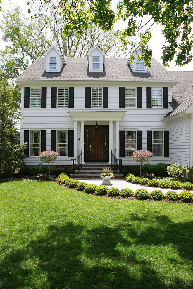 Стильный дизайн: двухэтажный, белый дом среднего размера в классическом стиле с двускатной крышей - последний тренд