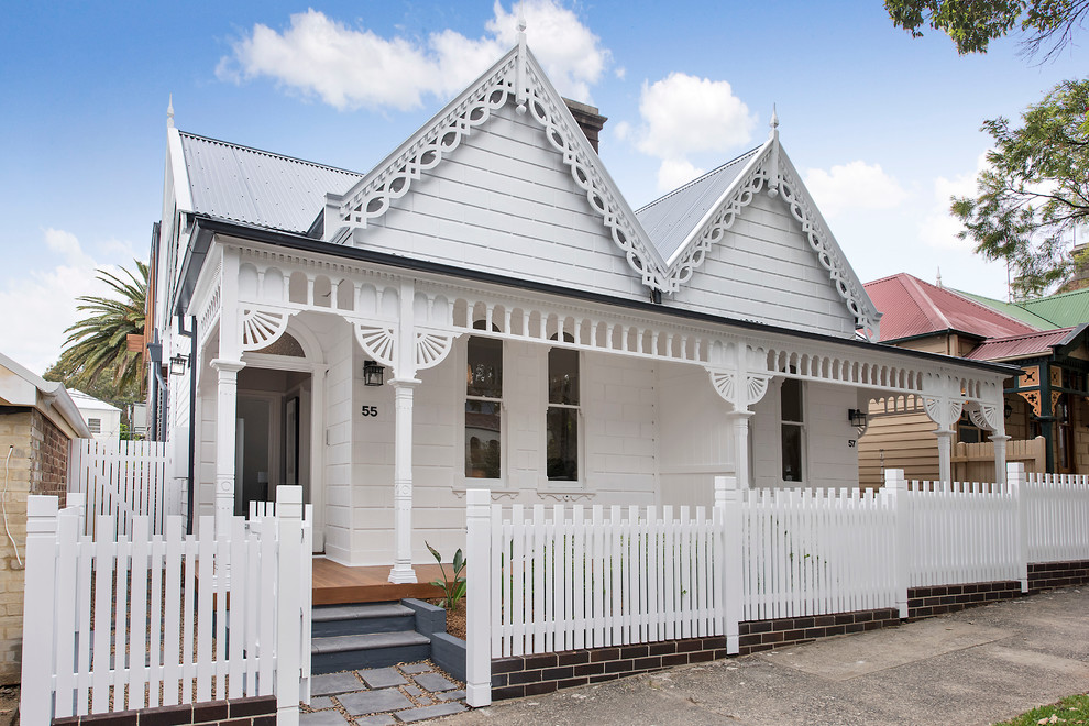 Стильный дизайн: белый, одноэтажный, деревянный таунхаус среднего размера в викторианском стиле с двускатной крышей - последний тренд