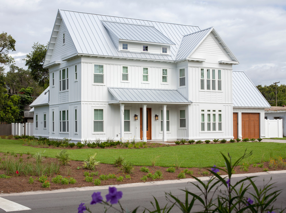 Immagine della facciata di una casa grande bianca country a tre piani con tetto a capanna