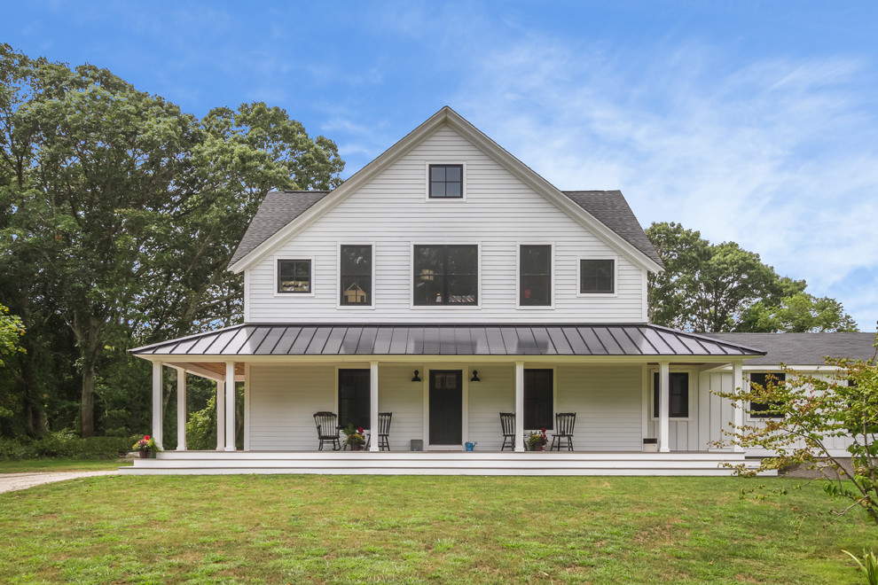 Cette photo montre une façade de maison blanche nature en panneau de béton fibré de taille moyenne et à un étage avec un toit à deux pans et un toit en métal.