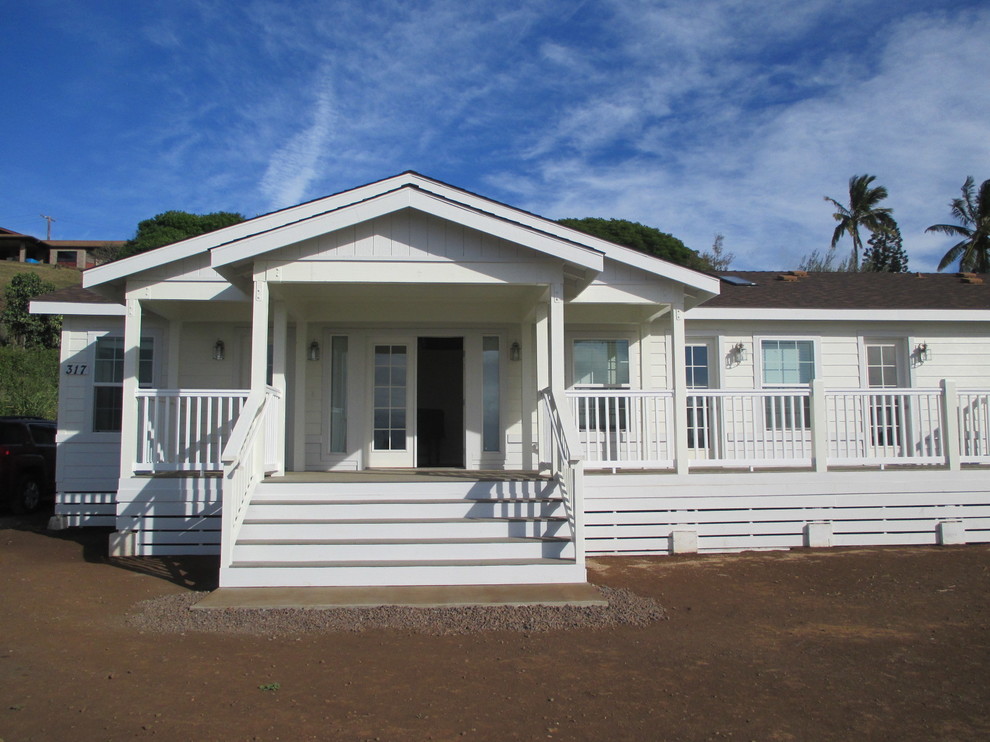 Cette photo montre une façade de maison blanche bord de mer en panneau de béton fibré de plain-pied et de taille moyenne avec un toit à deux pans.