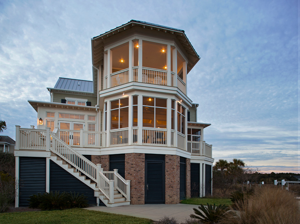 Modelo de fachada beige costera grande de tres plantas con revestimiento de madera y tejado a dos aguas