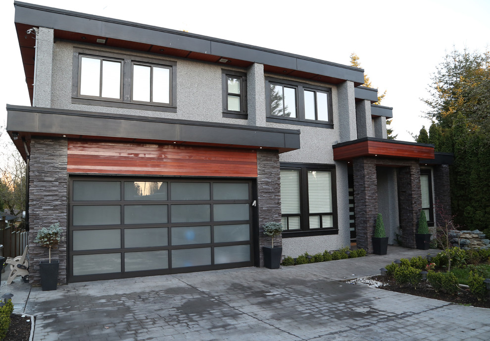 Mittelgroßes, Zweistöckiges Modernes Einfamilienhaus mit Mix-Fassade, grauer Fassadenfarbe, Flachdach und Schindeldach in Vancouver