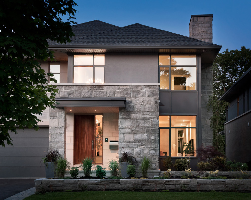 Ispirazione per la facciata di una casa contemporanea con rivestimento in pietra e tetto a padiglione