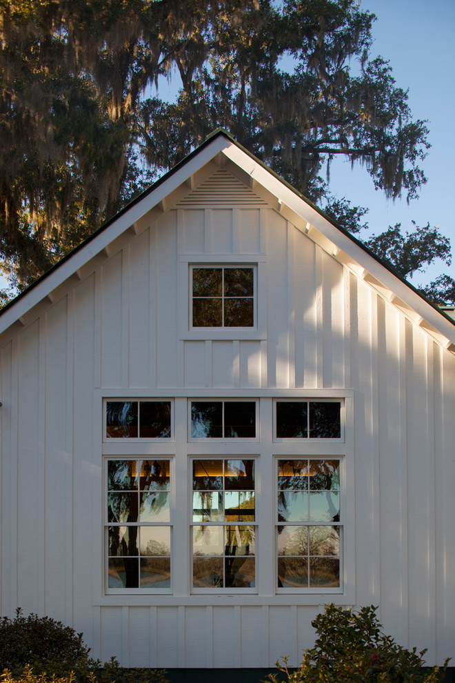 Diseño de fachada blanca de estilo de casa de campo grande de una planta con revestimiento de madera y tejado a dos aguas