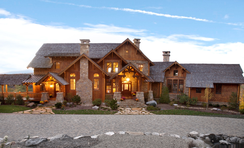 Cette photo montre une très grande façade de maison marron montagne en bois à un étage avec un toit à deux pans.
