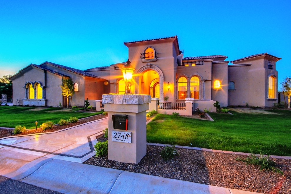 Example of a mid-sized tuscan beige one-story stucco exterior home design in Phoenix