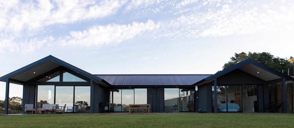 Idee per la villa nera contemporanea a un piano di medie dimensioni con rivestimento in legno, tetto a padiglione e copertura in metallo o lamiera