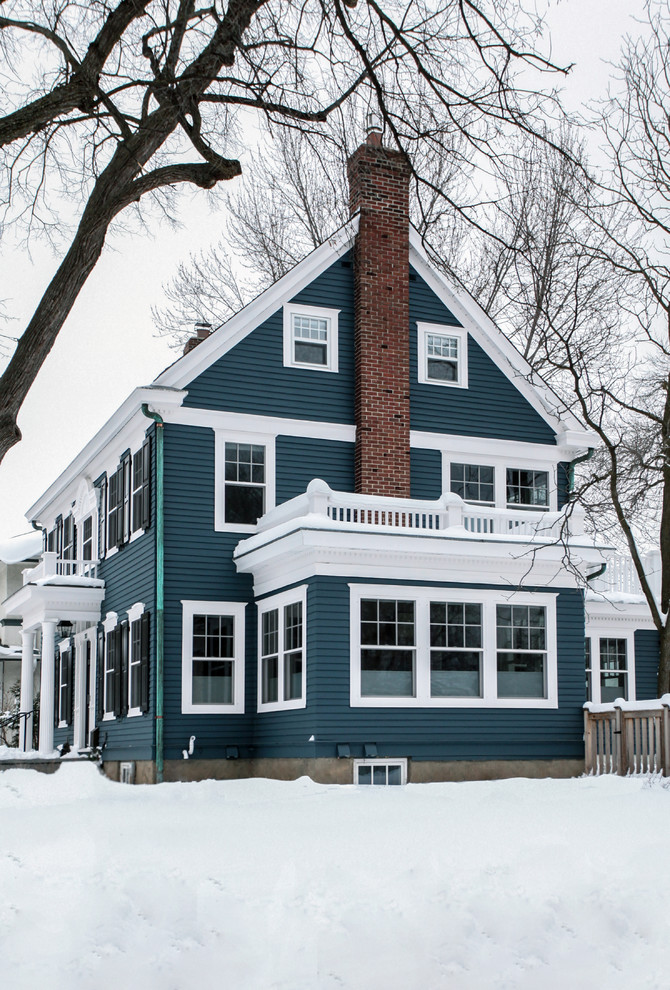 На фото: двухэтажный, синий, большой, деревянный частный загородный дом в классическом стиле с двускатной крышей и крышей из гибкой черепицы с