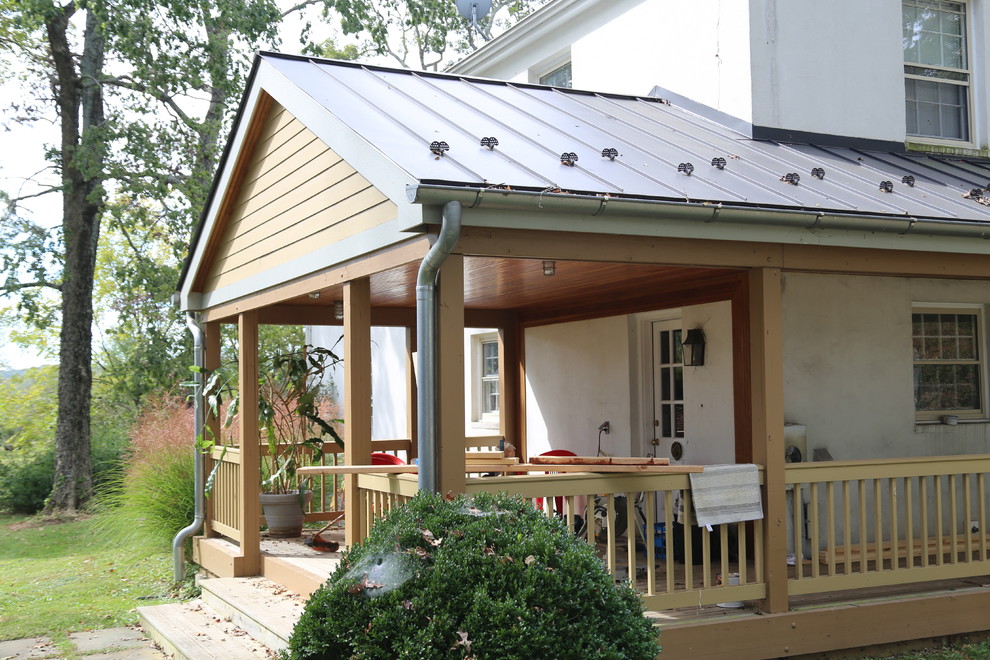Idée de décoration pour une façade de maison blanche champêtre en stuc de taille moyenne et à un étage avec un toit à deux pans et un toit en métal.