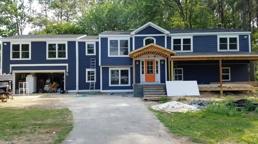 Imagen de fachada de casa azul clásica grande a niveles con revestimientos combinados, tejado a dos aguas y tejado de teja de madera