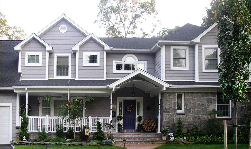 Exempel på ett mellanstort klassiskt blått hus, med två våningar, vinylfasad och sadeltak