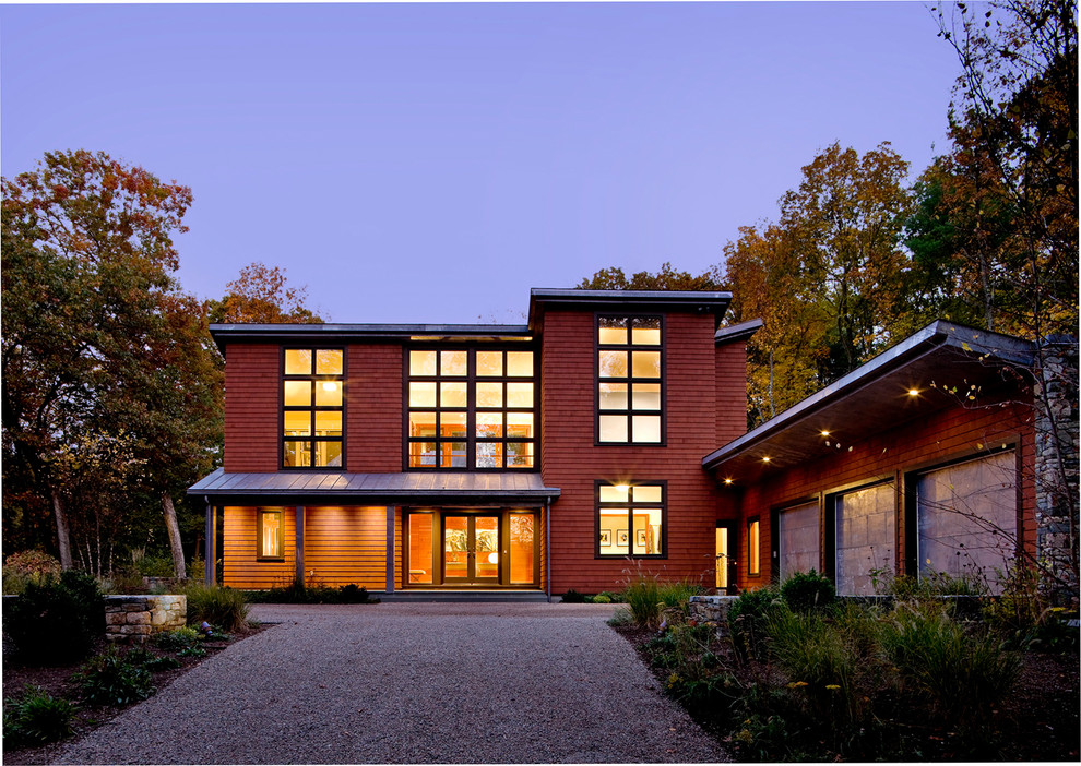 Exemple d'une grande façade de maison rouge tendance en bois avec un toit plat.
