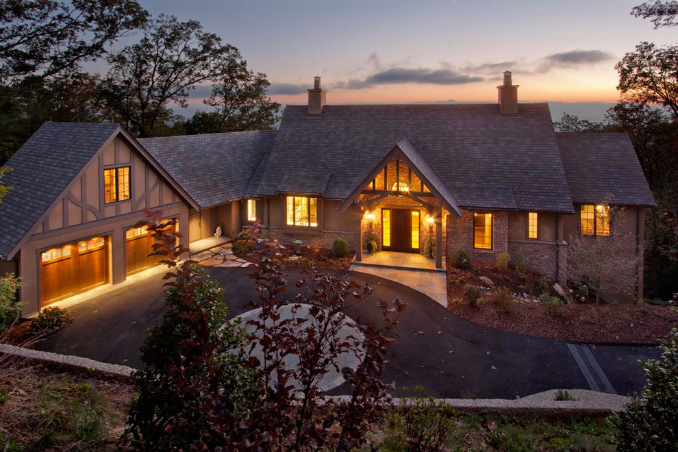 Inspiration pour une grande façade de maison marron traditionnelle en stuc à un étage avec un toit à deux pans.