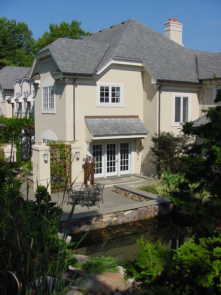 Cette photo montre une façade de maison chic à un étage avec un toit à croupette.