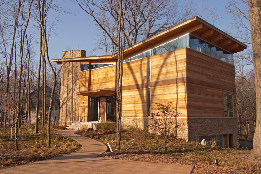 Стильный дизайн: деревянный, большой, трехэтажный, коричневый частный загородный дом в стиле модернизм с двускатной крышей и металлической крышей - последний тренд