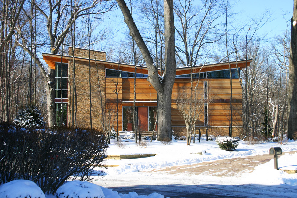 Ejemplo de fachada de casa marrón moderna grande de tres plantas con revestimiento de madera, tejado a dos aguas y tejado de metal