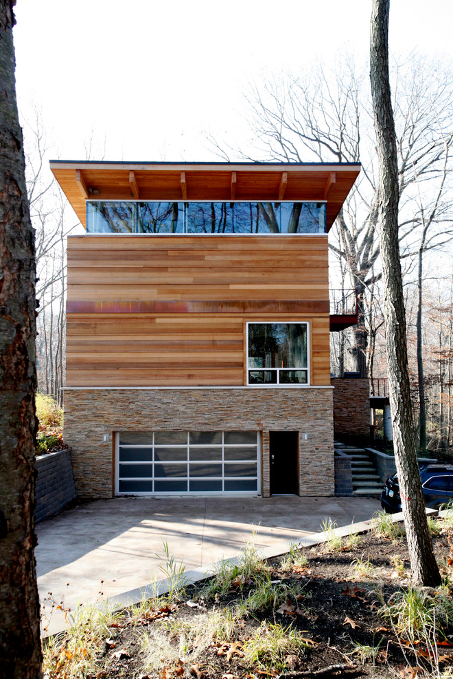 Diseño de fachada de casa marrón minimalista grande de tres plantas con revestimiento de madera, tejado a dos aguas y tejado de metal