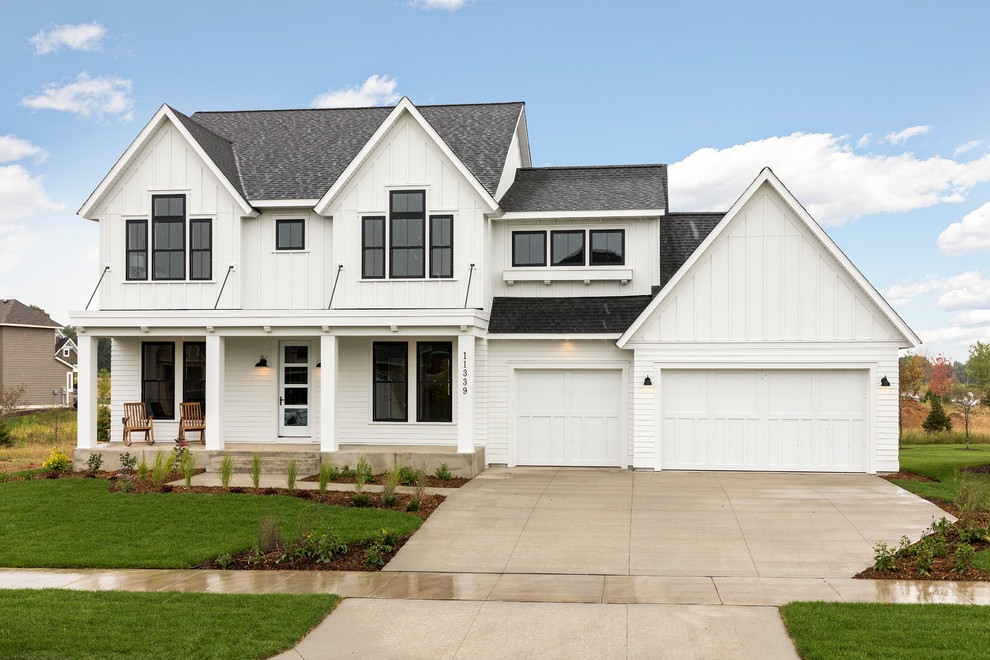 Imagen de fachada de casa blanca de estilo de casa de campo de dos plantas con revestimientos combinados, tejado a dos aguas y tejado de teja de madera