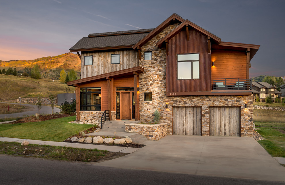 Réalisation d'une façade de maison marron chalet de taille moyenne et à un étage avec un revêtement mixte, un toit à deux pans et un toit mixte.