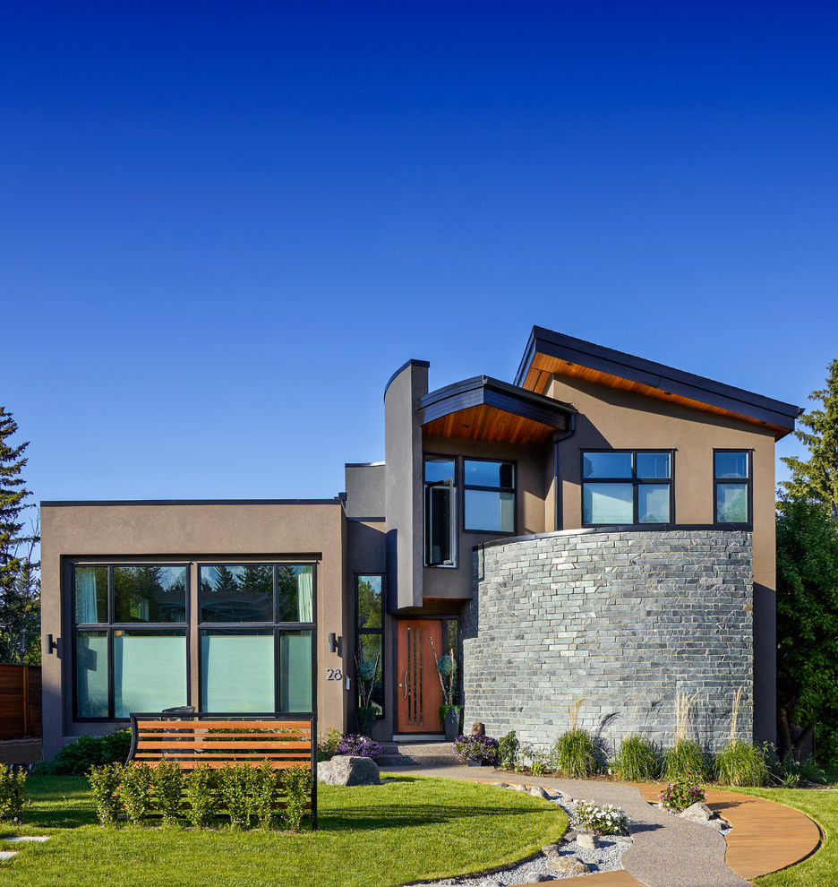 Design ideas for a medium sized and brown contemporary two floor render house exterior in Calgary.