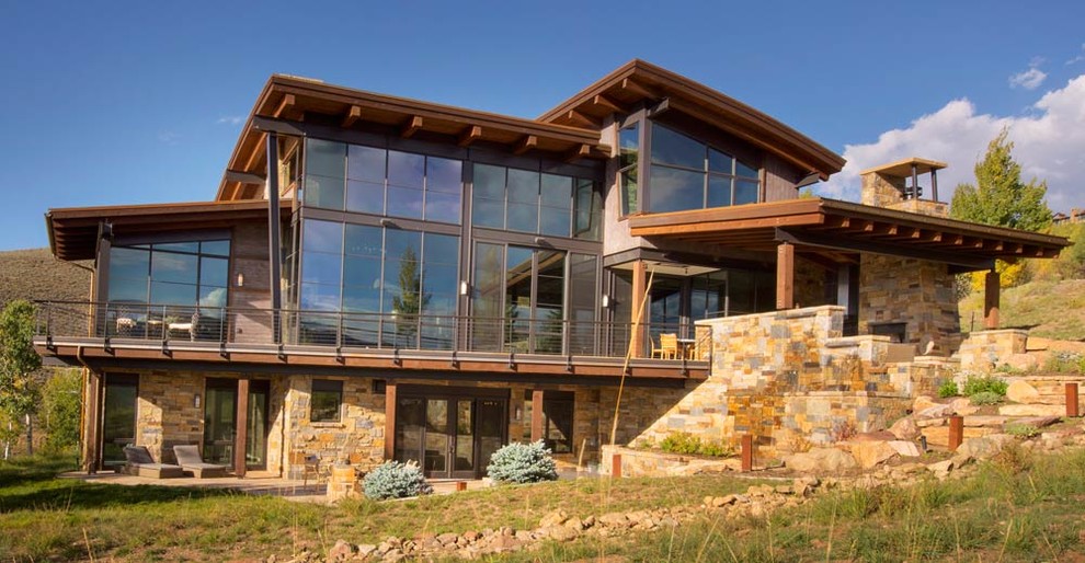 Example of a large transitional brown three-story stone exterior home design in Denver
