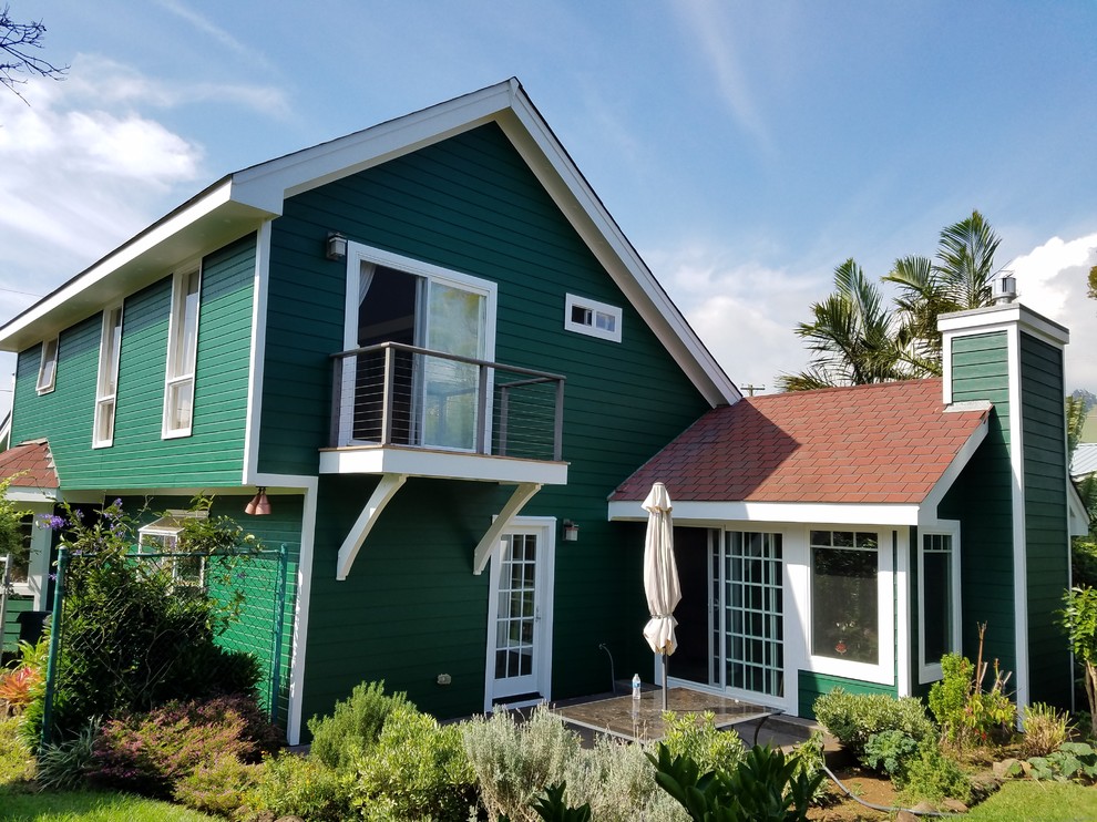 Aménagement d'une façade de maison verte craftsman en bois de taille moyenne et à un étage avec un toit à deux pans et un toit en tuile.