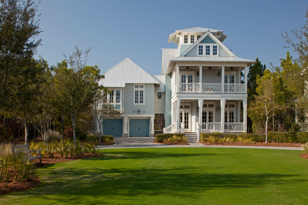 Example of a mid-sized beach style blue three-story exterior home design in Miami