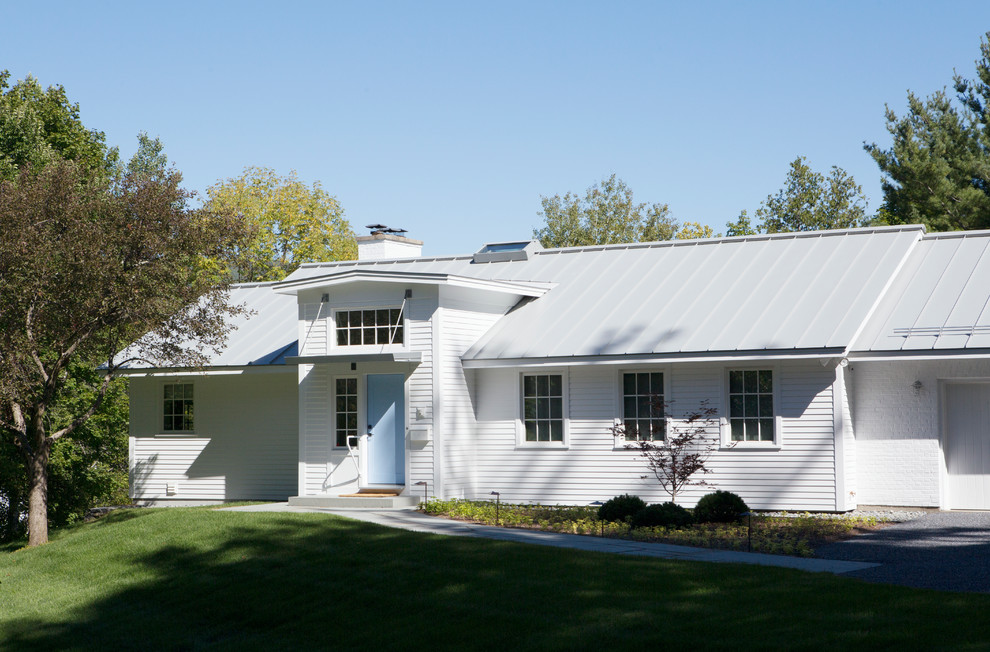 Cette photo montre une grande façade de maison blanche moderne en panneau de béton fibré à un étage avec un toit en appentis.