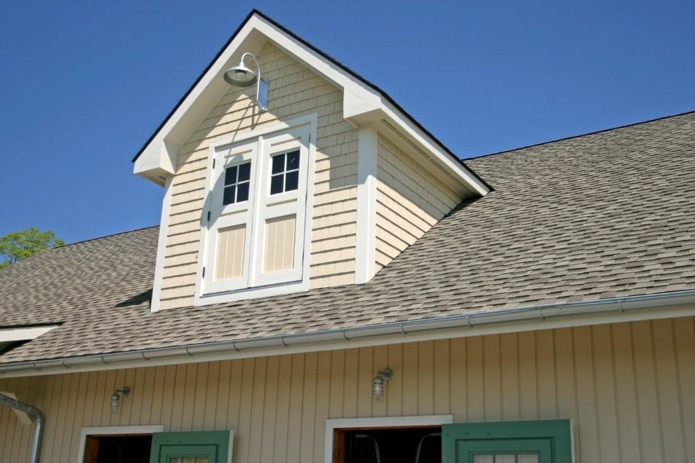 Aménagement d'une façade de maison beige campagne de taille moyenne et à un étage avec un toit à deux pans.