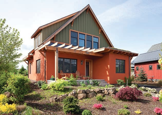 Cette image montre une grande façade de maison orange craftsman en béton à un étage avec un toit à quatre pans et un toit en shingle.