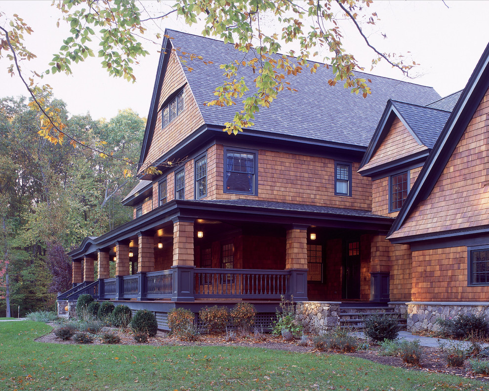 Diseño de fachada marrón clásica grande de tres plantas con revestimiento de madera y tejado a dos aguas