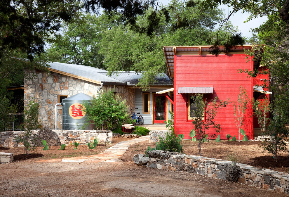 Einstöckiges, Kleines Uriges Haus mit Mix-Fassade, roter Fassadenfarbe und Pultdach in Austin