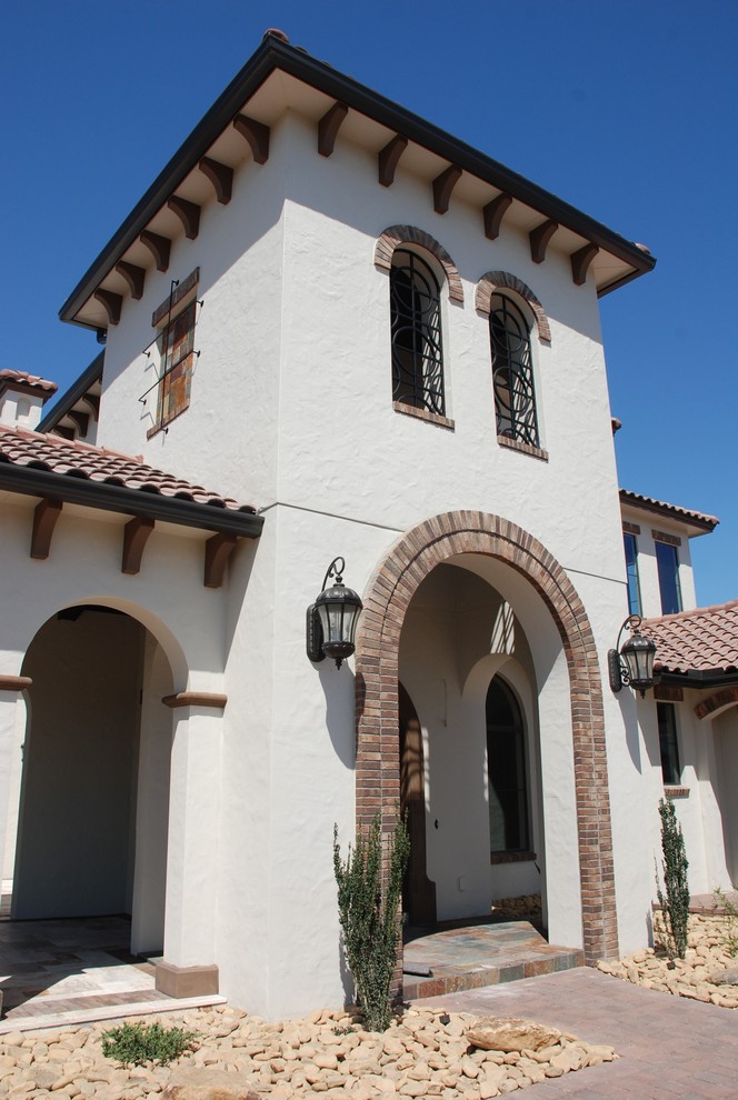 Inspiration for a mid-sized mediterranean white two-story mixed siding gable roof remodel in Orlando