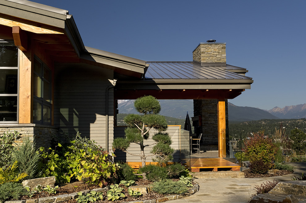 Idée de décoration pour une très grande façade de maison grise chalet à un étage avec un revêtement mixte, un toit en appentis et un toit en métal.