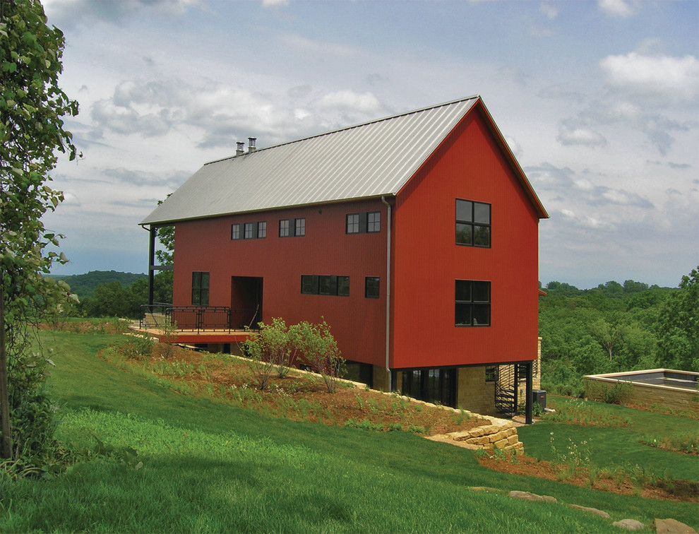 Esempio della villa grande rossa country a due piani con rivestimento in legno, tetto a capanna e copertura in metallo o lamiera