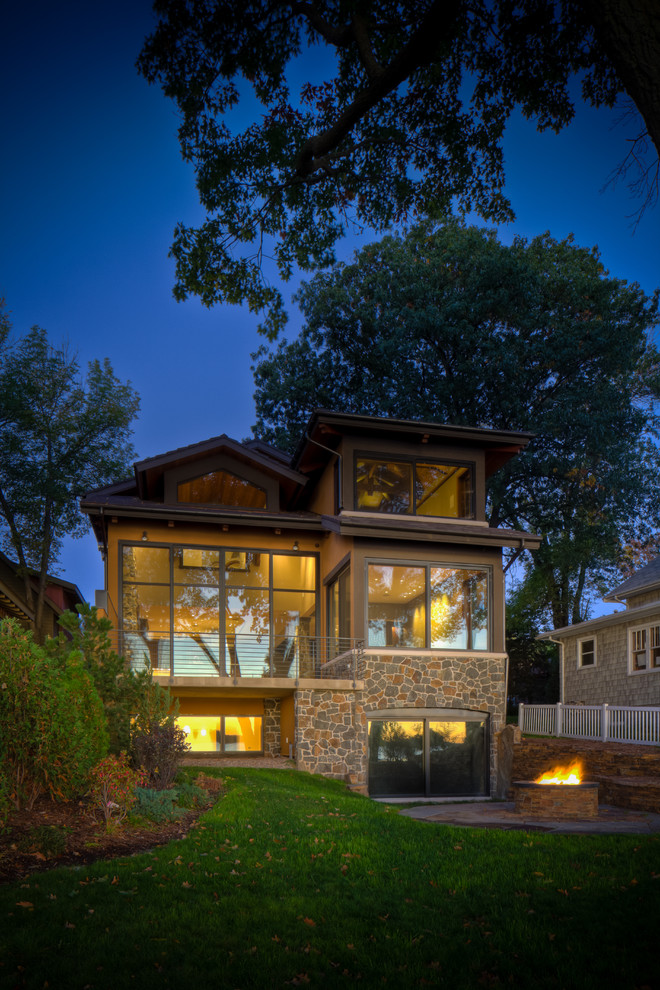 Стильный дизайн: двухэтажный, бежевый, большой дом в современном стиле с комбинированной облицовкой и двускатной крышей - последний тренд