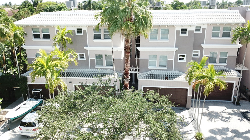 マイアミにある高級なモダンスタイルのおしゃれな家の外観 (ガラスサイディング、混合材屋根) の写真