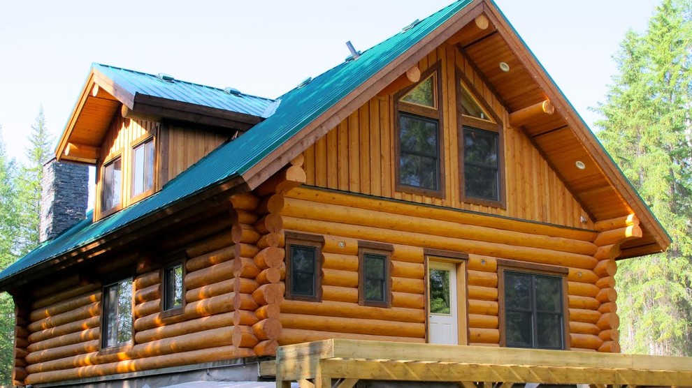 На фото: трехэтажный, деревянный, коричневый частный загородный дом среднего размера в стиле рустика с двускатной крышей и металлической крышей с