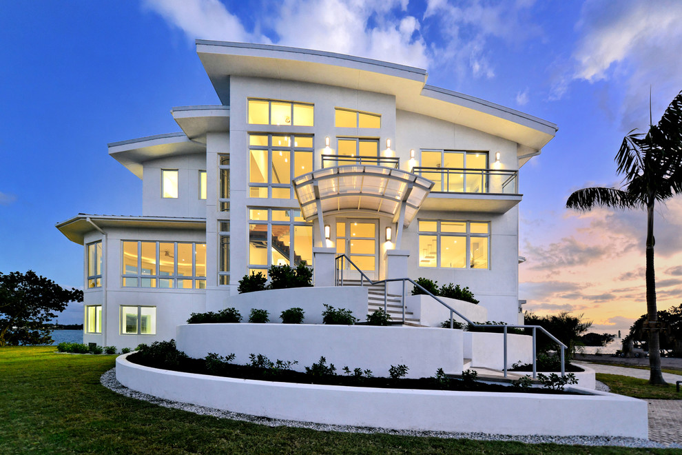 Cette image montre une façade de maison blanche design en stuc de taille moyenne et à deux étages et plus.