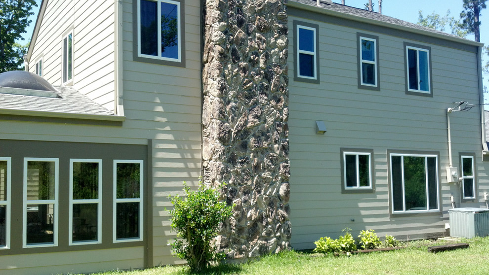 Cette image montre une grande façade de maison grise traditionnelle à un étage avec un revêtement en vinyle.