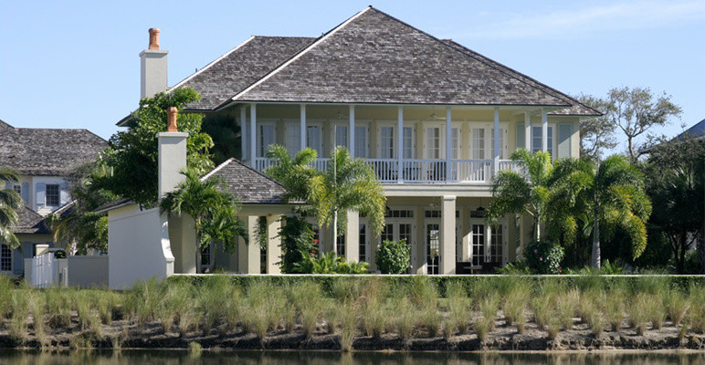 Großes, Zweistöckiges Haus mit Putzfassade, gelber Fassadenfarbe und Halbwalmdach in Miami