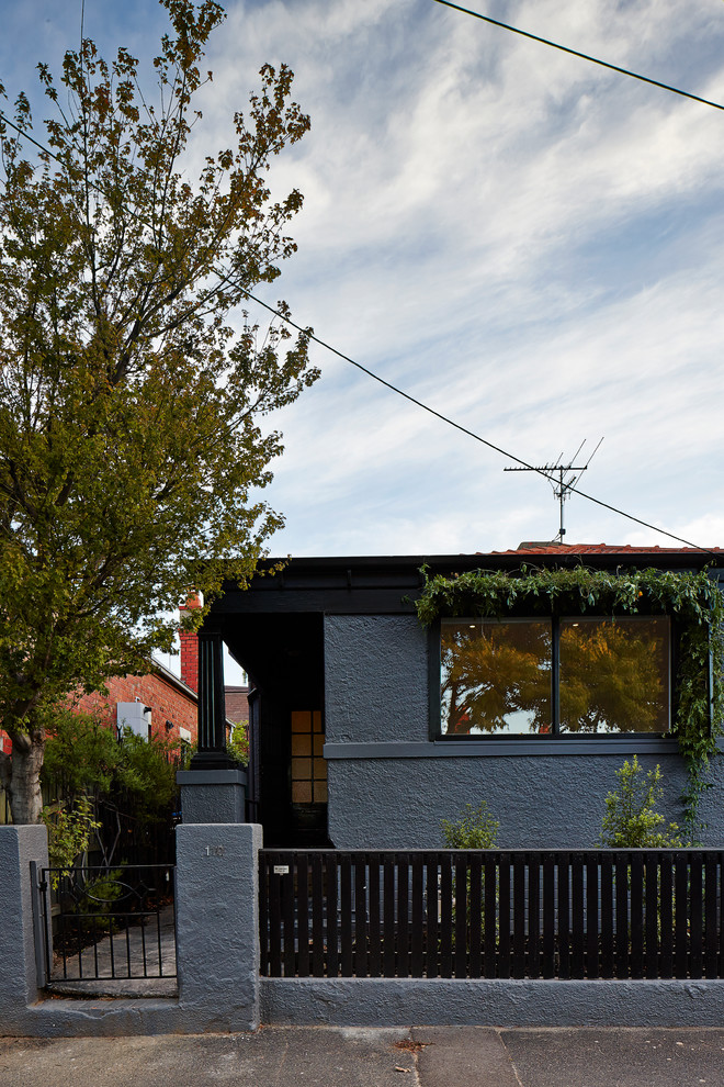 Пример оригинального дизайна: маленький, одноэтажный, серый дом в современном стиле с облицовкой из цементной штукатурки для на участке и в саду