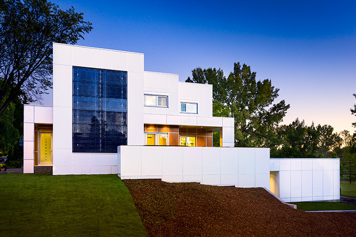 Idée de décoration pour une grande façade de maison blanche minimaliste en panneau de béton fibré à un étage avec un toit plat.
