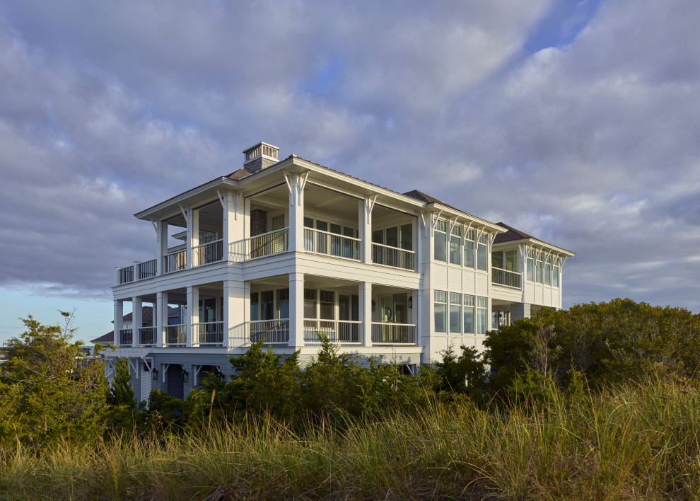 Стильный дизайн: огромный, двухэтажный, деревянный, серый частный загородный дом в морском стиле с полувальмовой крышей и крышей из гибкой черепицы - последний тренд