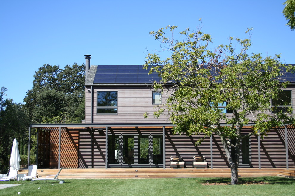 Inspiration pour une grande façade de maison marron minimaliste en bois à un étage.