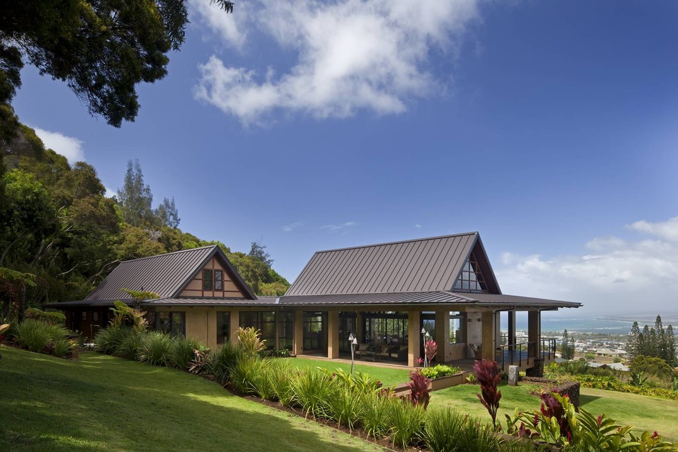 ハワイにある高級なトロピカルスタイルのおしゃれな家の外観 (漆喰サイディング) の写真