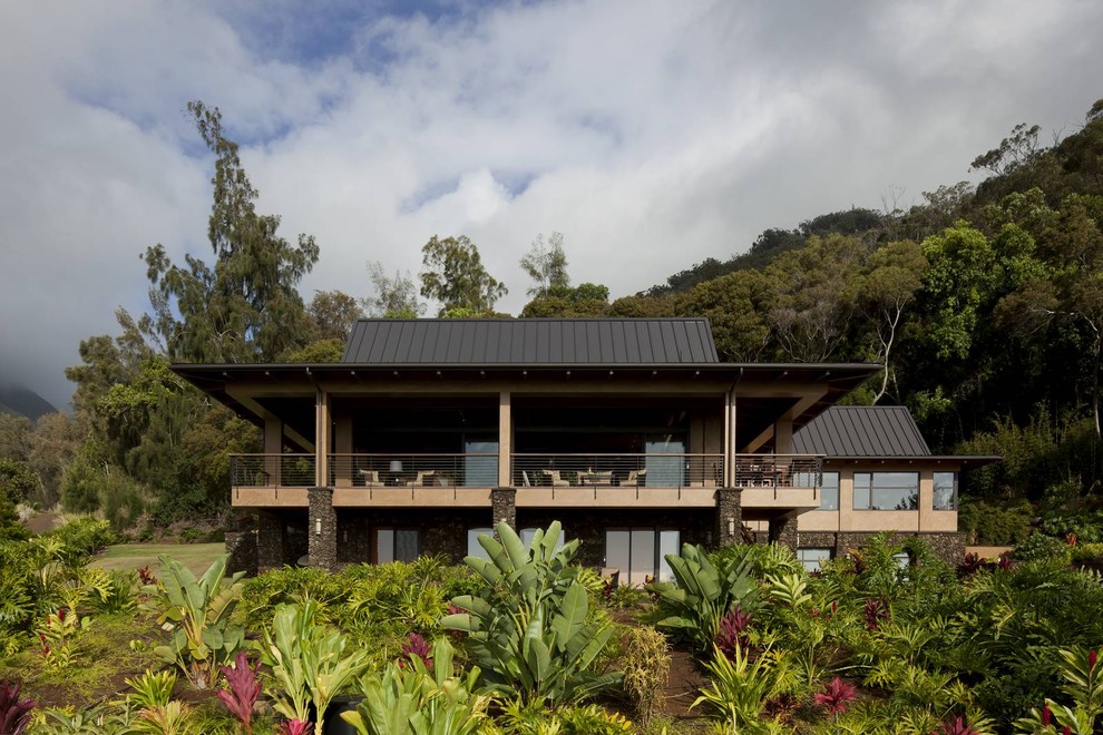 Ispirazione per la villa grande beige tropicale a due piani con rivestimento in stucco, tetto a padiglione e copertura in metallo o lamiera