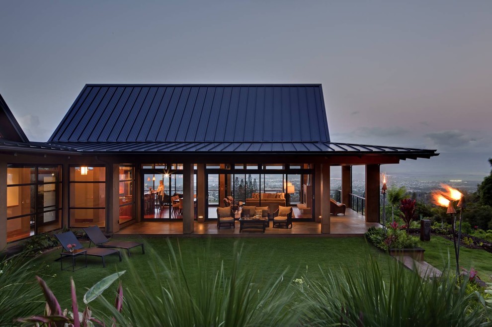 Foto de fachada de casa beige tropical grande de dos plantas con revestimiento de estuco, tejado a cuatro aguas y tejado de metal