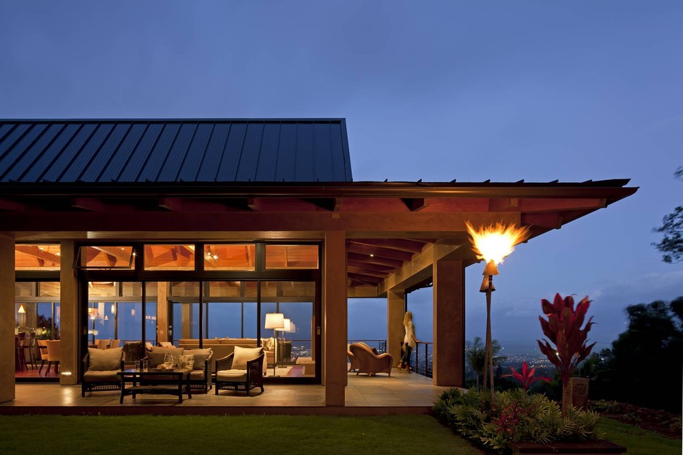 Esempio della villa grande beige tropicale a un piano con rivestimento in vetro, tetto a padiglione e copertura in metallo o lamiera